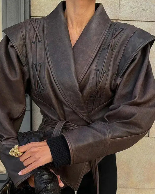 Model wearing Liora Structured Wrap Jacket in rich faux leather with exaggerated shoulders and cinched waist, showcasing modern femininity.
